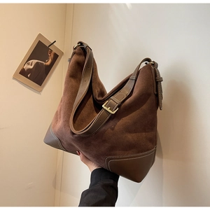 Detail of vintage brown suede hobo bag with contrast stitching and leather corner patches