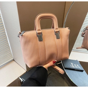 Detail view of pink corduroy handbag texture with silver metal hardware and handle