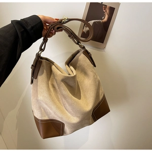 Detail of vintage beige suede tote bag with brown leather handles and contrast stitching