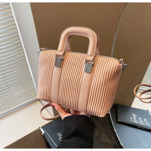 Detail of pink pleated texture tote bag with silver metal hardware and sturdy handle