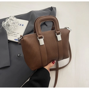 Detailed macro shot of brown pleated tote bag with silver hardware and detachable strap