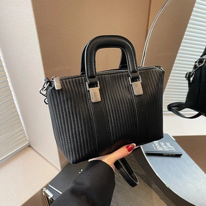 Women's black textured leather bucket bag with vertical stripes and silver hardware