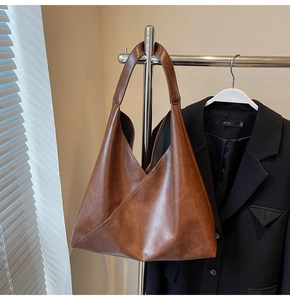 Detail shot of brown faux leather tote bag showing unique triangular patchwork design