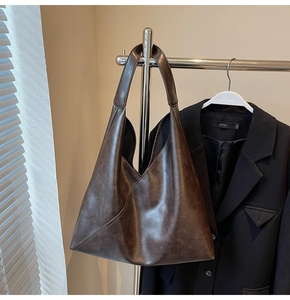 Detail view of large dark brown tote bag with diagonal stitching and retro matte finish
