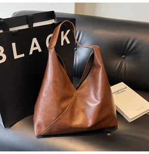 Detail showing the brown faux leather tote bag with unique V-shaped asymmetrical stitching