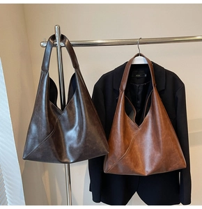 Detail view of large tote bags in coffee and caramel colors with faux leather texture