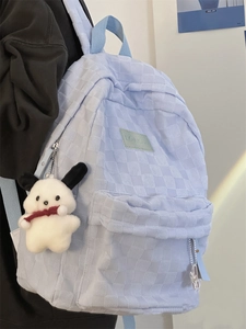 Λεπτομέρεια γαλάζιου σακιδίου με καρό ανάγλυφη υφή και κρεμαστό λούτρινο σκυλάκι