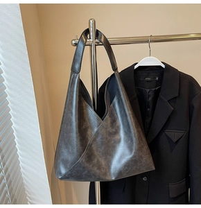 Detail of large vintage grey tote bag with geometric triangle stitching on a metal hanger