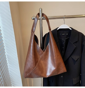 Detail of vintage brown tote bag with oily leather texture and unique V-cut design