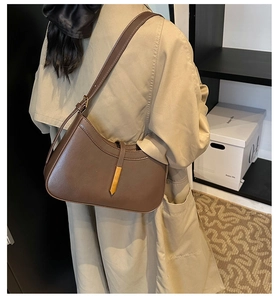 Détail de sac hobo en cuir marron foncé avec bandoulière réglable et détails dorés