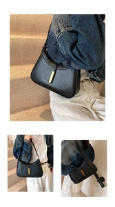 Détail du sac sous l'aisselle en cuir noir à grain de litchi avec boucle dorée