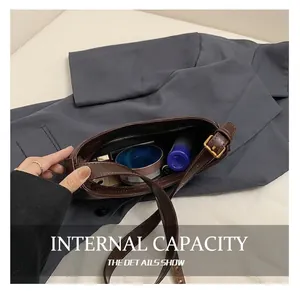 Détail de la capacité intérieure du sac croissant en cuir marron avec rangement et poche zippée