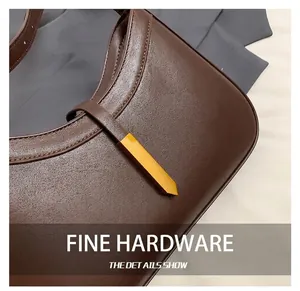 Détail de la texture en cuir marron foncé avec fermeture en métal doré élégante de la sacoche