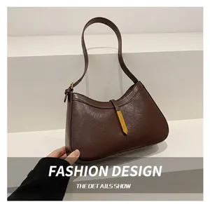 Détail du sac hobo marron foncé avec fermoir doré et bandoulière réglable pratique