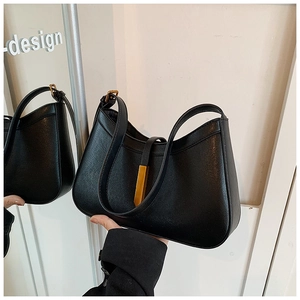 Détail d'un sac à main minimaliste en cuir noir avec boucle en métal doré élégant