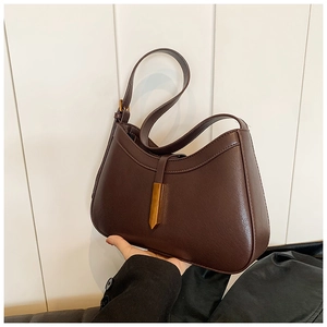 Détail du sac demi-lune en cuir marron foncé avec boucle dorée et bandoulière réglable