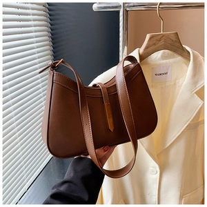 Détails d'un sac à bandoulière en cuir marron foncé avec finitions en métal doré