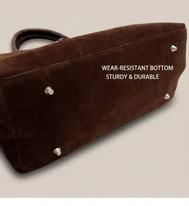 Detailed base of dark brown frosted tote bag with protective silver metal studs