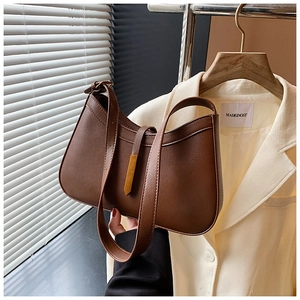 Détail du sac à bandoulière vintage en similicuir marron foncé avec boucle dorée