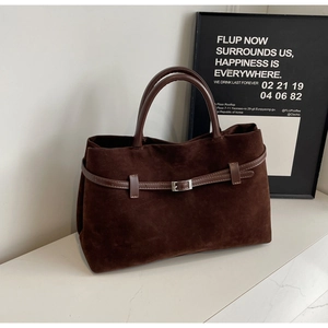 Detail of dark brown matte suede tote bag featuring a decorative metal buckle and strap