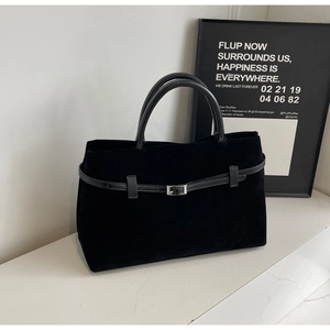 Detail of matte black tote bag showing soft suede texture and silver metal buckle strap