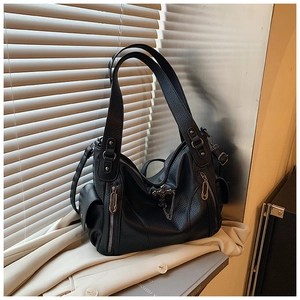 Close-up of black litchi pattern leather tote bag with vintage metal zipper and hardware