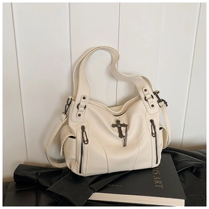 Detail of lychee pattern leather tote bag with cross pendant and metal chain tassels
