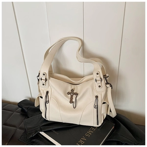 Detail of off-white lychee texture tote with vintage metal cross and zip accents
