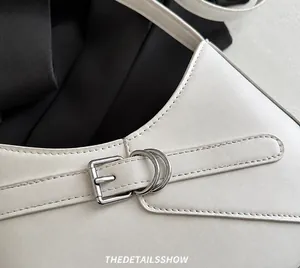 Détail du sac à bandoulière en cuir blanc avec boucle argentée et coutures fines