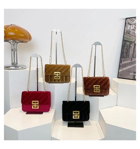 Detail of four velvet chain bags in red, yellow, black and brown with gold buckles