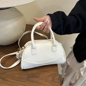 White minimalist PU leather bowling handbag with gold hardware and shoulder strap