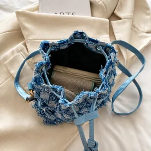 Detail view of denim bucket bag interior showing spacious storage and frayed texture