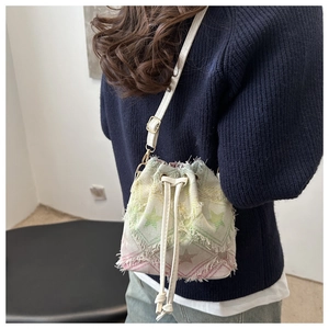 Détail du sac seau à imprimé étoiles colorées avec bords effilochés et cordon de serrage
