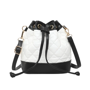 Modern white quilted bucket bag with black leather trim and drawstring for women
