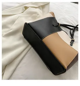 Close-up of three-color stitching and white decorative seams on textured leather tote bag