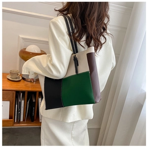 Detail of color-block tote bag with adjustable shoulder straps in a chic study room