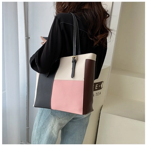 Detail view of large color-block tote bag showing real-life shoulder carrying effect