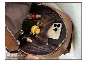 Interior view of brown leather backpack showing large capacity and zipper pocket
