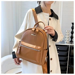 Caramel brown pebbled leather backpack shown on model with adjustable straps