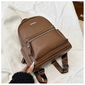 Detail of dark brown pebble leather backpack with silver hardware and adjustable straps