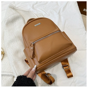 Macro view of brown lychee grain leather backpack with silver metal buckle and zip pocket