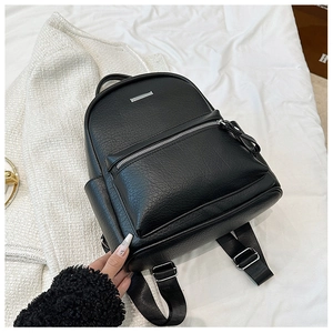 Close-up of black lychee texture leather mini backpack with silver zipper and metal detail