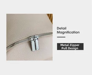 Detail magnification showing hardware zipper pull design on beige leather backpack