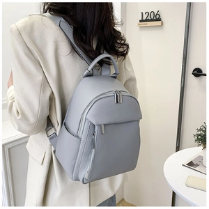 Close-up of soft faux leather texture and zipper detail on light blue women's backpack