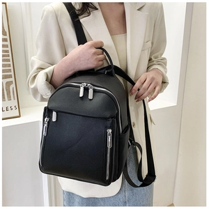 Classic black pebbled leather backpack shown on model with urban casual style outfits