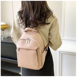 Close-up of soft faux leather texture and metallic zipper on the pink backpack