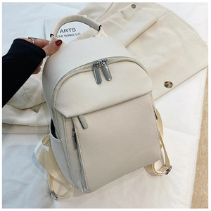 Detailed macro view of white lychee grain leather backpack with silver metal zippers
