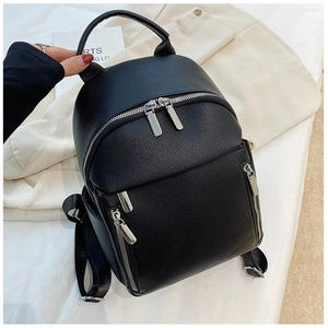 Detailed view of black litchi grain leather mini backpack with silver zipper pockets