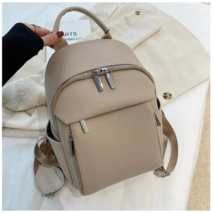 Detail shot of the beige backpack featuring lychee grain texture and silver zippers