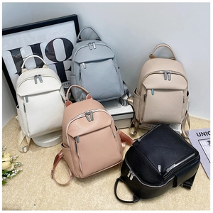 Detailed view of 5 colorful mini leather backpacks featuring rich lychee grain texture
